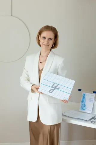 Вероника Мазина показывает магнитные элементы букв на планшете с разлиновкой