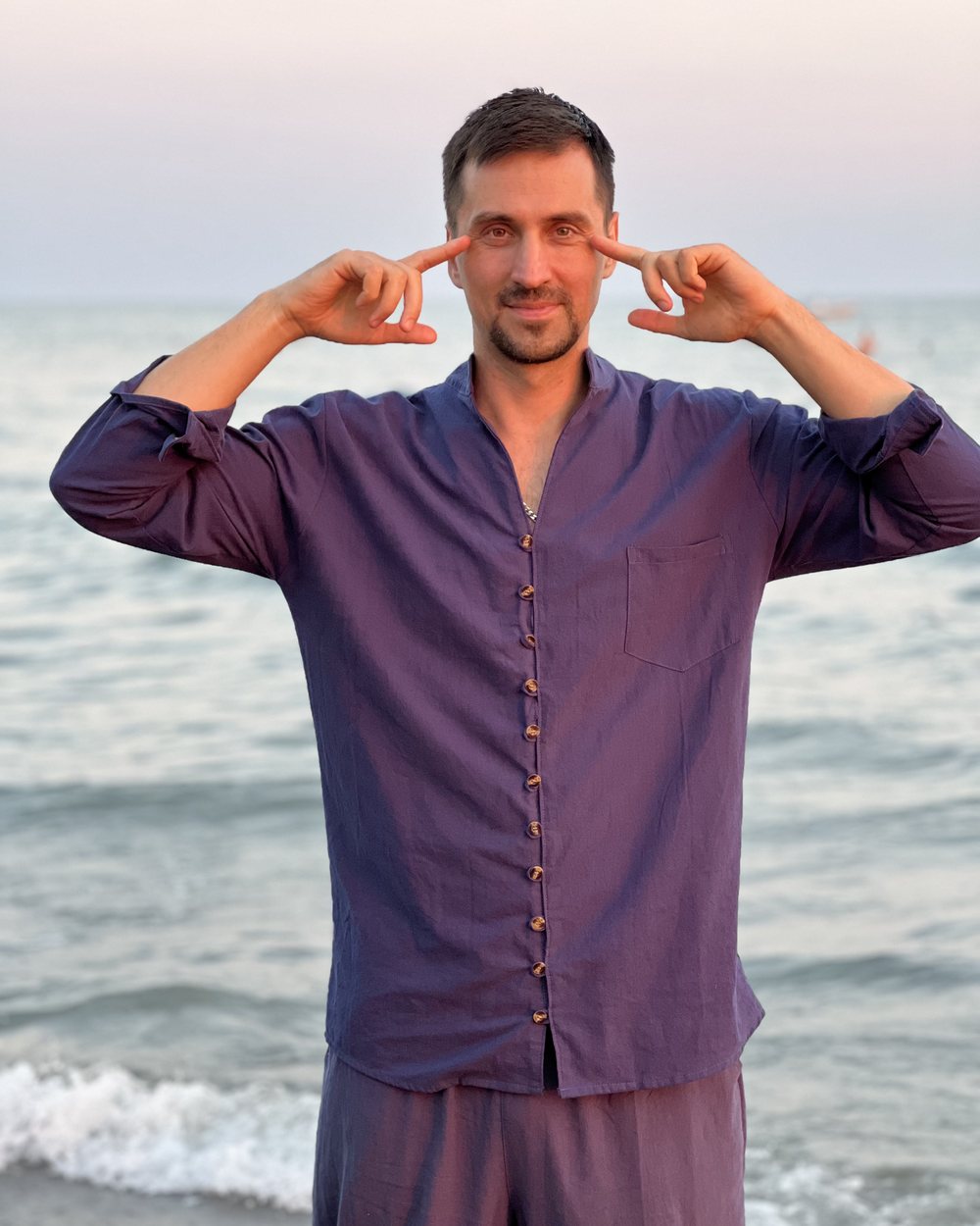 Fedor Simonov am Meer, die Zeigefinger an den Schläfen bei einer Augenübung