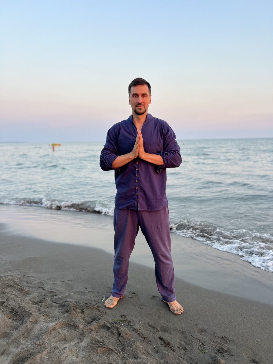 Fedor Simonov am Strand in einer Qigong-Haltung